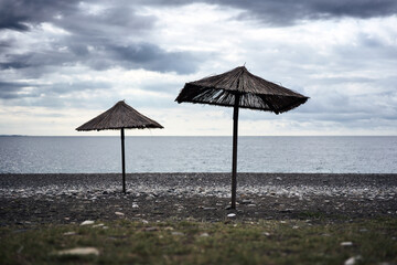 Two beach umbrellas on empty beach