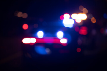 Night time abstracted blurred view of police lights. - obrazy, fototapety, plakaty