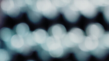 Blurred white Bokeh of light on black background in vintage tone. Green lighting blurry wallpaper.