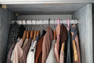 Fashion design closet with clothes hanging on clothes hangers