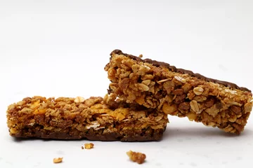 Foto op Plexiglas anti-reflex protein bar isolated on white background, mixture of grains and chocolate, snack high in fiber and protein, diet food. © Andri