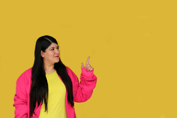 Excited and happy 30-year-old Latin woman shows and points with her hands to promotions and discounts