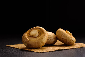 Fresh organic button mushroom placed on black background. Local ingredient for healthy vegetarian meal