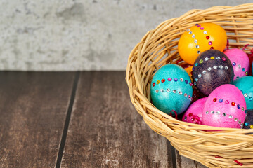 Easter eggs in a vintage basket on a wooden table