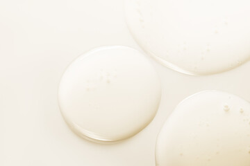 Oil drops. Liquid gel texture. Cosmetic product on light beige color background