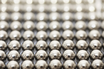 magnetic ball bearing tiling in perfect hexagonal grid. Metal balls close up. Balls of neodymium (magnets).