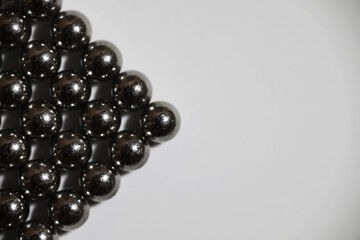 magnetic ball bearing tiling in perfect hexagonal grid. Metal balls close up. Balls of neodymium...