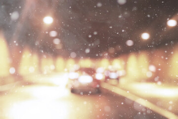 De focused/blur image of city at winter night. Snowflakes with blurred urban abstract traffic...