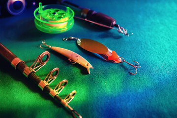 objects for fishing on a wooden pier close-up - hooks, baits, coil and hat