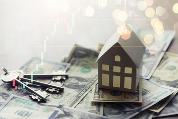 House model and Money, house key lying on real estate contract, home loan and investment concept.