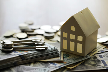Model of cardboard house with key and dollar bills. Building, loan, real estate, cost of housing or...