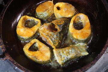 fried fish pieces on iron pan