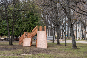 Children playground in the public park. New wooden slide for sliding.