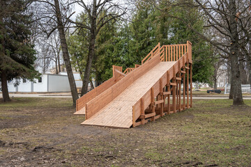 Children playground in the public park. New wooden slide for sliding.