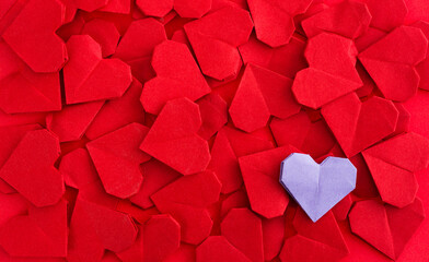 Purple origami heart on red origami hearts