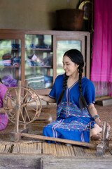 Pretty Karen Asian woman wearing local dress traditional fabrics and textiles weaving beautiful unique craftsmanship and famous sarong at old house at Chiang Mai, Northern Thailand.