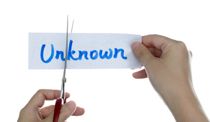 Scissors cutting word unknown on paper