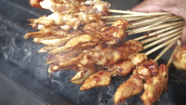 Preparing satay sate taichan for customers. Sate skewered and grilled meat served with spicy salad, chili, cucumber and soy sauce. In Java, as a local take on the skewered kebab introduced.