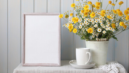 summer rural mockup. an empty frame and a bouquet of daisies on the table in the cottage. empty space for your text.