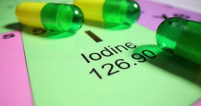 Tablets pill with iodine on the colorful periodic table of the elements