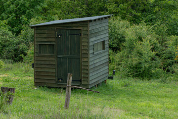 A wooden wildlife photography hide in woodland.