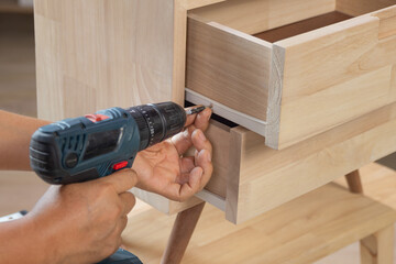 Handyman fixing over tight drawer slides rail of bedside table. - 784273227