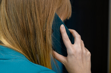 Rozmowa telefoniczna. Kobieta trzyma telefon komórkowy przy uchu - obrazy, fototapety, plakaty