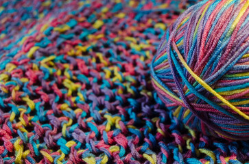Ball of multi coloured wool on a crotched blanket with depth of field
