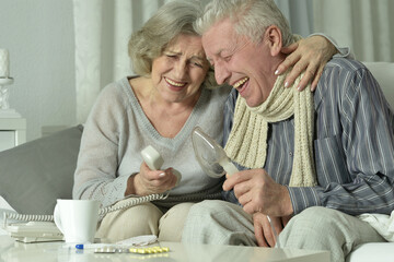 An elderly couple is sick and uses an inhaler