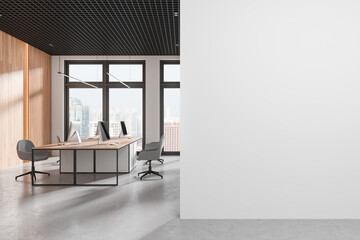 Office coworking interior with pc monitors on tables, window. Mockup wall