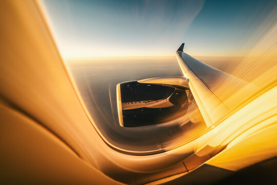 ultra wide view of engine and wing from inside at sunset