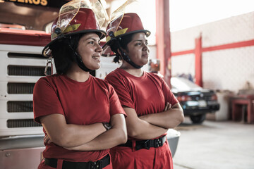 Portrait of smiling female firefighter standing at fire station