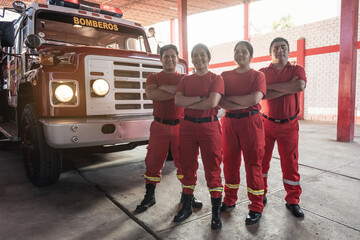 Portrait of a team of male and female firefighters with fire truck