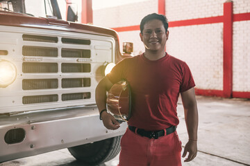 Portrait of latin fireman standing at fire station