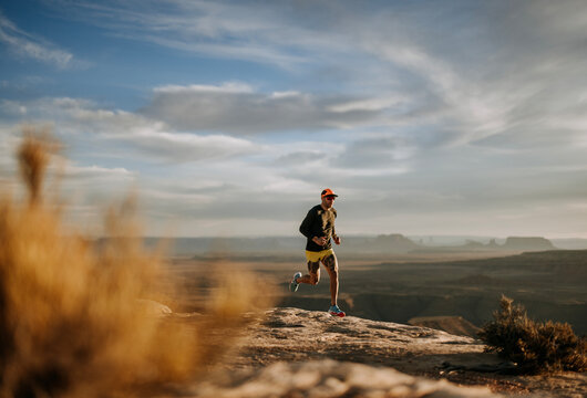 Male runner jogs at sunset through beautiful Utah desert.