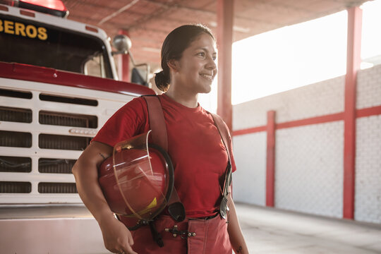 Portrait of happy female firefighter standing at fire station