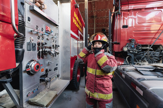 Female Firefighter In Fire Protection Suit standing at fire station