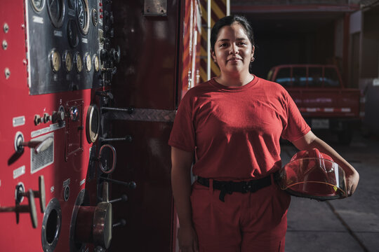 Portrait of female firefighter standing at fire station