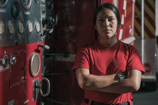 Portrait of female firefighter standing against fire engine