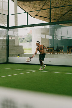 Man play padel tennis on an indoor court, Bali.