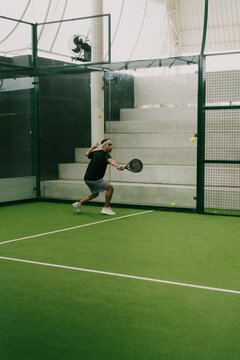 Man play padel tennis on an indoor court, Bali.