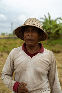 Balinese local man farmer wearing a straw hat.