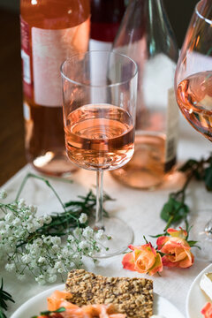 Tablescape with wine glasses and bottle, roses, and crackers on