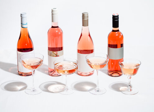 Four varieties of Rose wine bottles poured into different wine g
