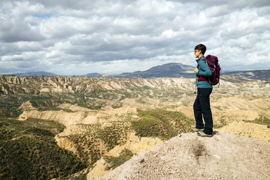 Hiker woman looking at arid desert landscape.