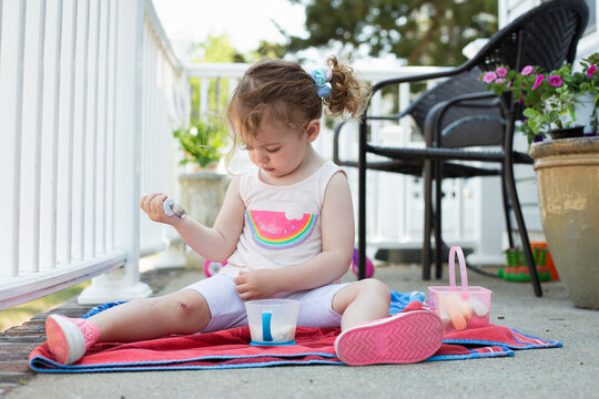 toddler sitting on beach towel with ice cream