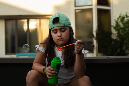 Girl blowing bubbles looking bored