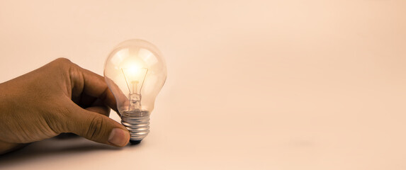 Hand choose light bulb with bright light for creative idea innovation of technology in analyzing...