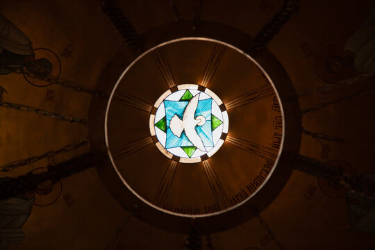 Colorful stained glass window with a winged dove .  Holy spirit. - Powered by Adobe