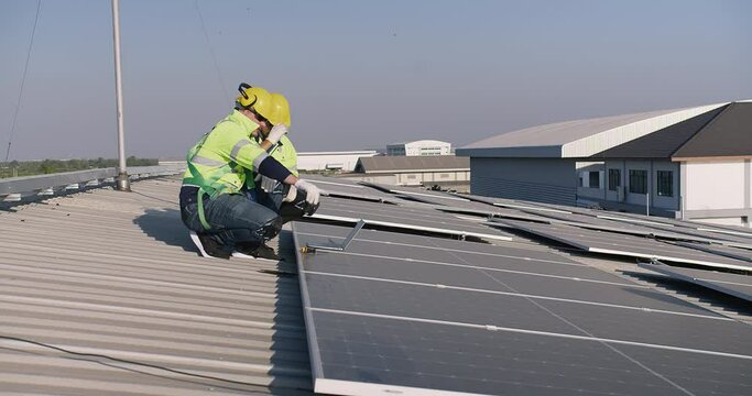 Technicians engineer in safety vests and helmets discussing analysis maintenance install solar panels on a metal roof, integrating sustainable energy solutions